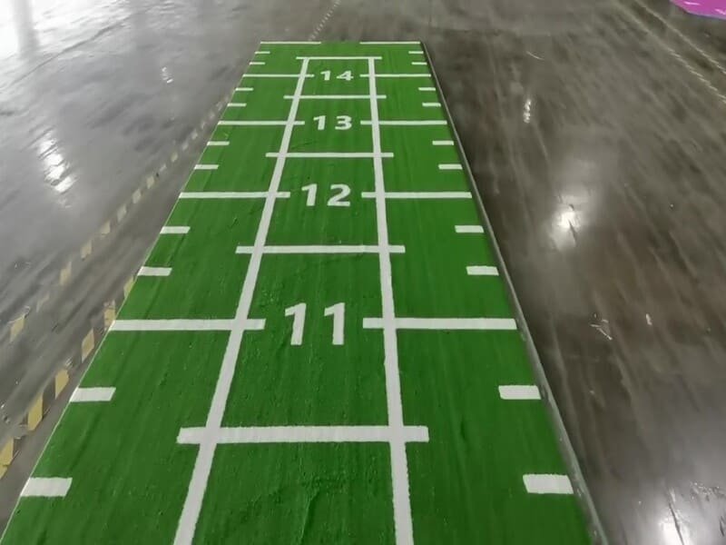 Laboratory equipment performing ASTM D1335 tuft bind test on artificial turf